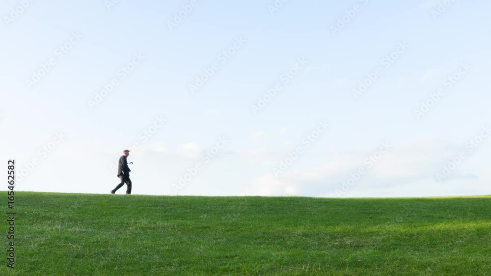 Low angle view of a Happy carefree middle aged Caucasian businessman dancing on a hill themes of messing about daydreaming dancing Low angle view of a Happy carefree middle aged Caucasian businessman dancing on a hill themes of messing about daydreaming dancing
