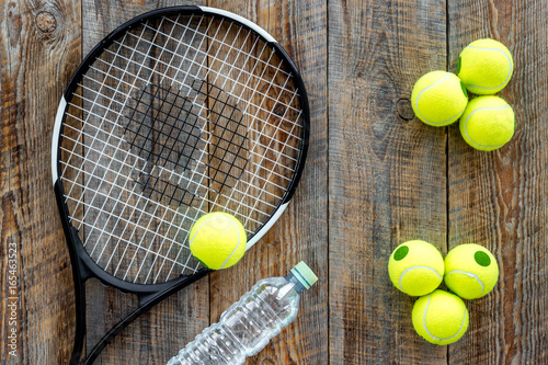 Sport background. Tennis balls and racket on wooden background top view © 9dreamstudio