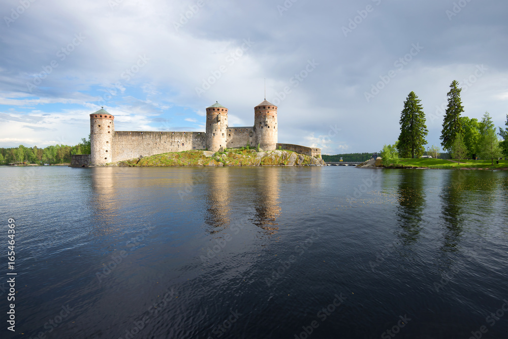 Kyurensalmi strait and medieval fortress of Olanvinlinn in the cloudy July afternoon. Savonlinna, Finland