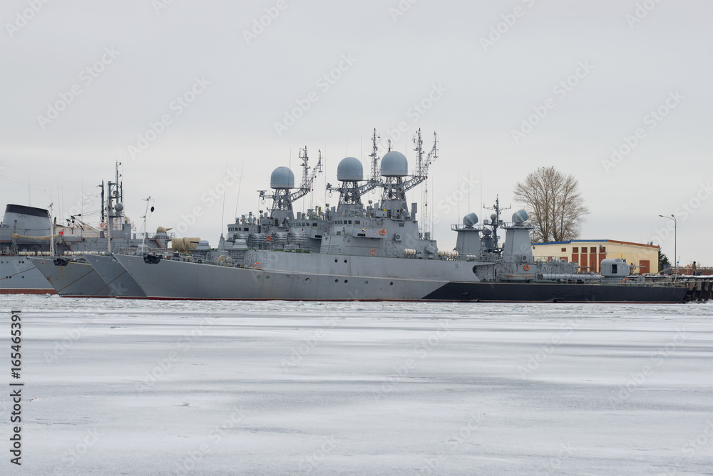 Fototapeta premium Small anti-submarine ships of the Baltic Navy in winter parking on a gloomy January day. Kronstadt