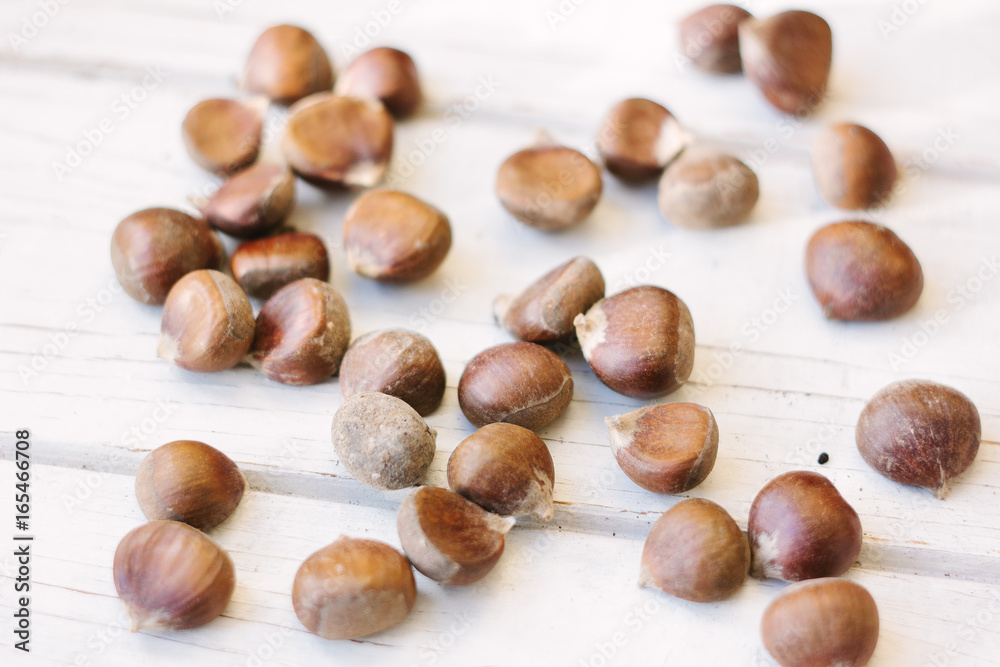 Fresh raw chestnuts on white wooden surface. Fresh raw chestnuts on white wooden surface.