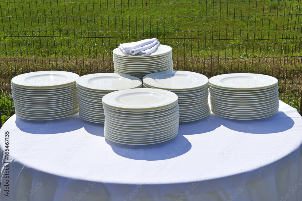 Ristorante, pile di piatti sul tavolo in esterno. Stock Photo | Adobe Stock