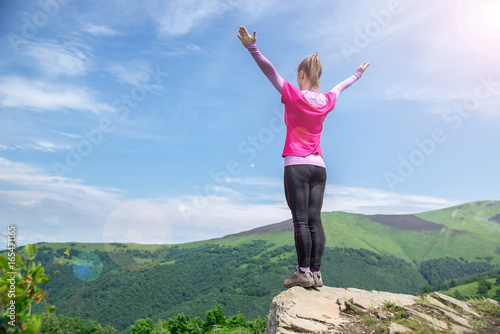 Young woman on the top of mountain