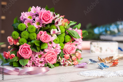 Bouquet of pink and red roses lies on a white wooden table  spase for text