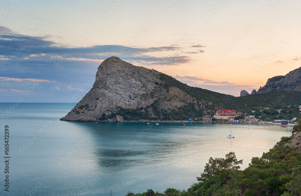 Large headland in the sea near the resort town in the Bay at sunset. Cape Chyken Peninsula of Crimea, resort Noviy Svet