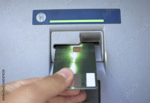 Hand of a man with credit cards, using an ATM. Man using an atm machine with his credit card.