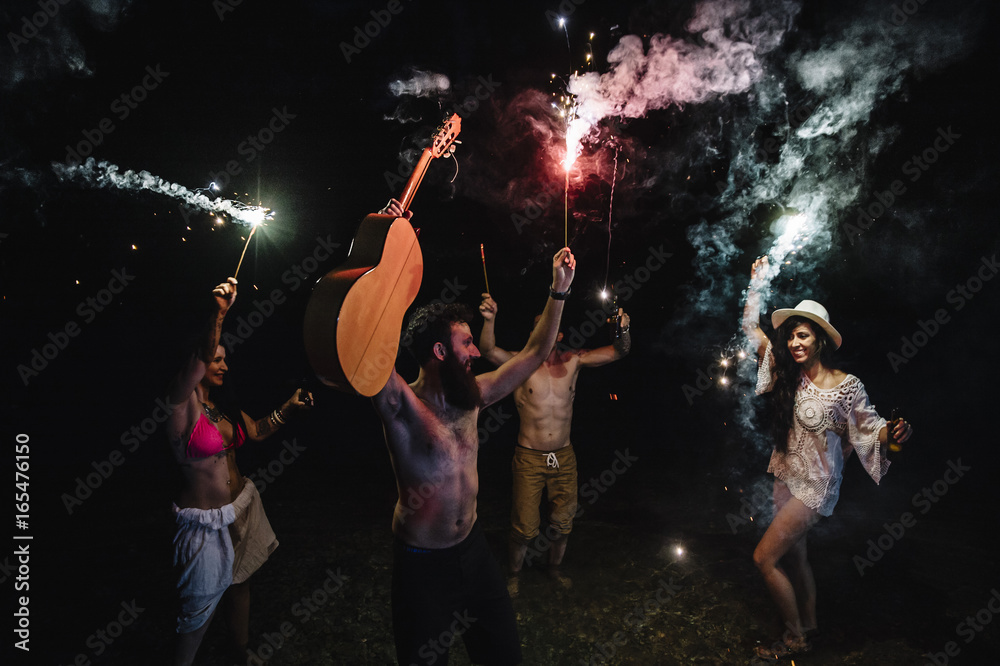 Friends playing with sparkles at the night