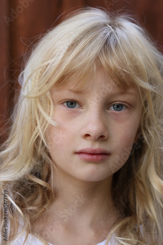 Close up portrait of a young blonde blue eyed girl photo