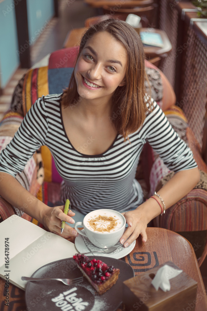 Young woman sitting indoor in urban cafe