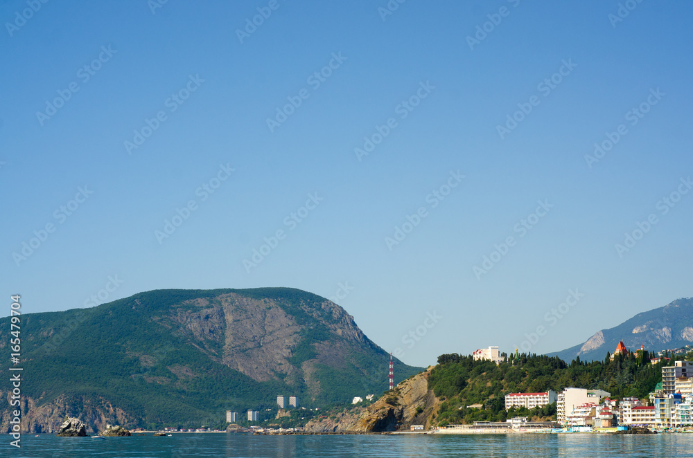 Fototapeta premium Mountain standing with a resort town by the sea