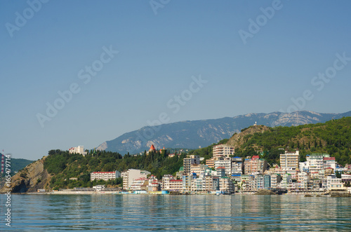 A resort town by the sea behind the mountains in the daytime
