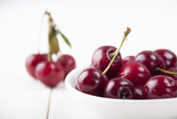 Cherries in a white plate on a white background
