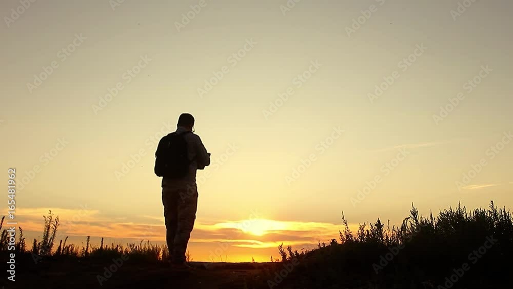 Silhouette of business man with laptop working on the field at sunset time. Concept freelancer, performing tasks, anger from failure and throwing a laptop. Silhouette of business man with laptop working on the field at sunset time. Concept freelancer, performing tasks, anger from failure and throwing a laptop.