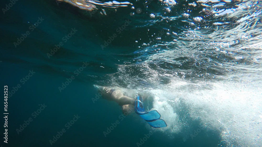 Obraz premium swimmer in flippers dives into the sea