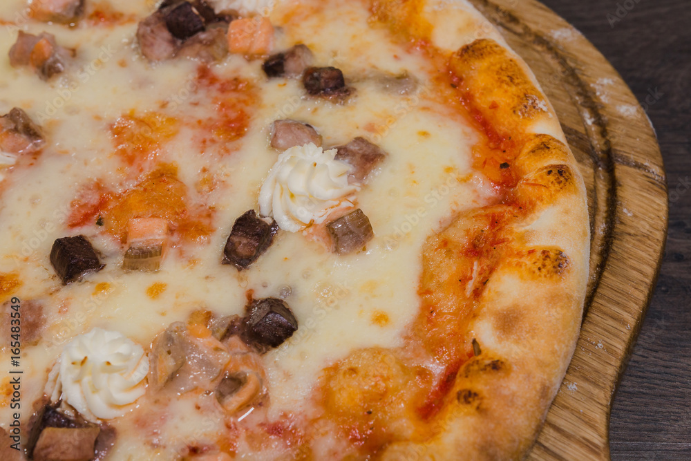 Hot piece of pizza with melted cheese on a rustic wooden table Hot piece of pizza with melted cheese on a rustic wooden table