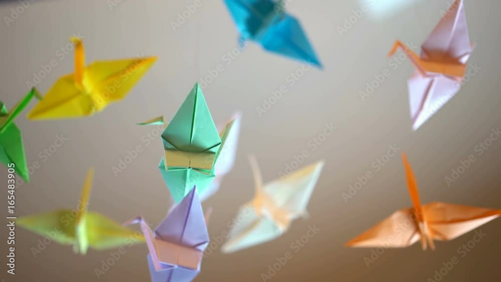 Colored origami crane birds waving in wind, summer breeze, first love, childhood
