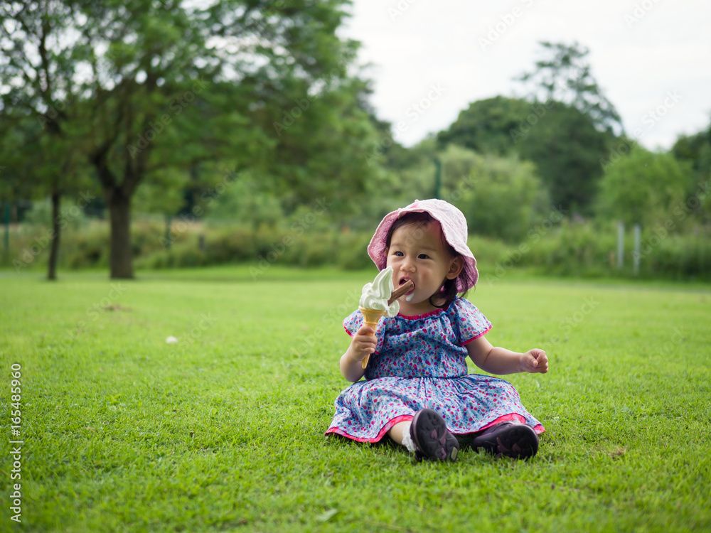 baby girl eating icecream in summer garden baby girl eating icecream in summer garden
