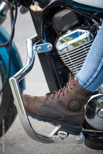 Motorcycle boot on the footboard of a motorcycle, close-up