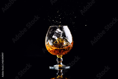 glass with cognac on a black background