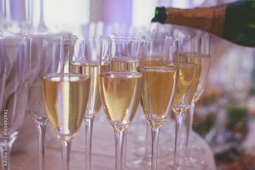 Line of different colored alcohol cocktails on a decorated catering banquet table on a party Line of different colored alcohol cocktails on a decorated catering banquet table on a party
