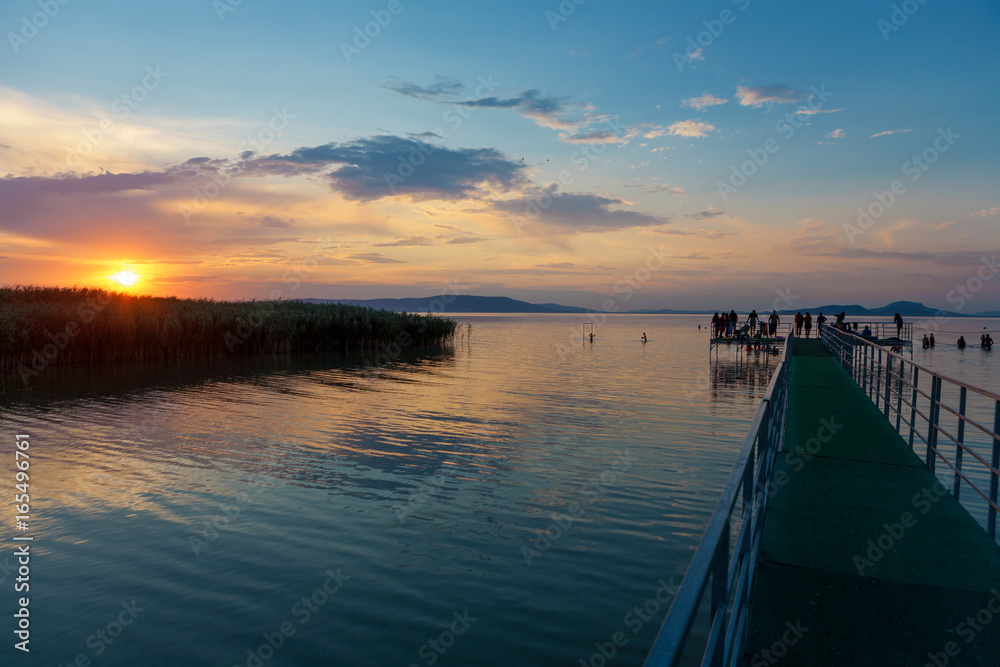 Sunset at Lake Balaton with pier and silhouettes in Hungary