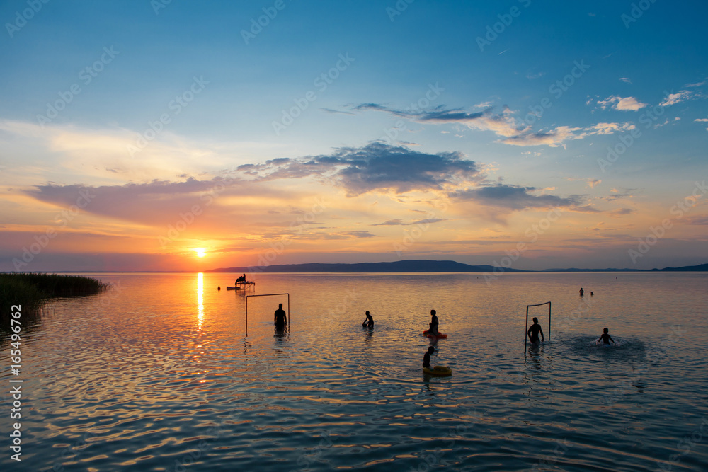 Bather's silhouettes at sunset in Lake Balaton, Hungary