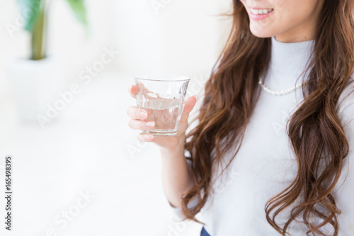 部屋で水を飲む女性　手元