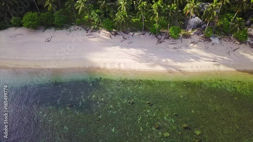 Aerial pullback reveal shot from the drone on a deserted, uninhabited beach of Thailand photo