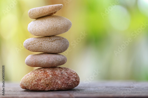 Balance Stone on wooden floor and soft sunlight in the garden.