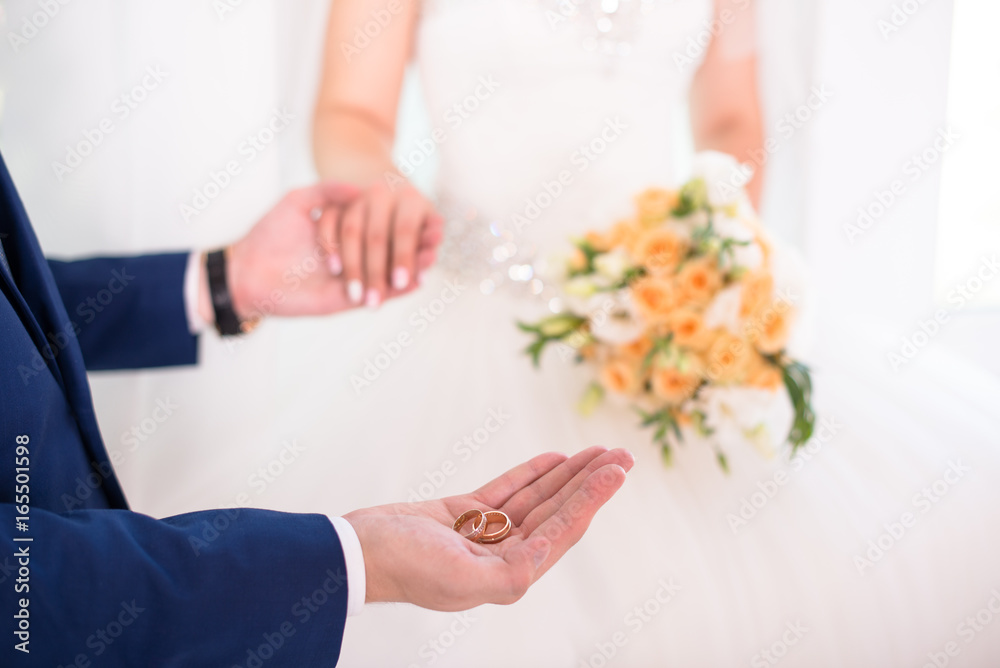 Groom holding wedding rings on the palm, the groom in a blue suit, groom holding wedding rings, groom's hand holding a ring, wedding ring in groom hand Groom holding wedding rings on the palm, the groom in a blue suit, groom holding wedding rings, groom's hand holding a ring, wedding ring in groom hand