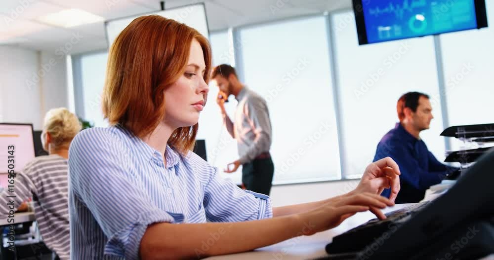 Female executive working on computer at desk Female executive working on computer at desk