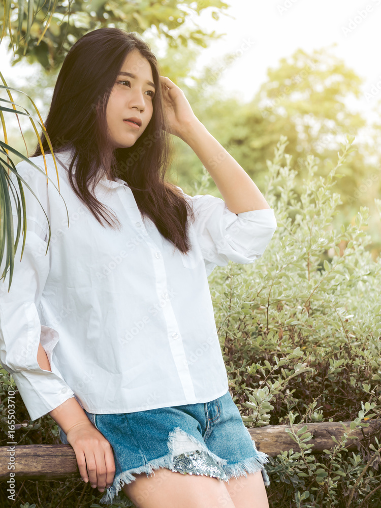 Portrait image of beautiful teenager girl is happy in nature garden.  Fashion woman in white shirt and denim shorts jeans with copy space Stock  Photo | Adobe Stock