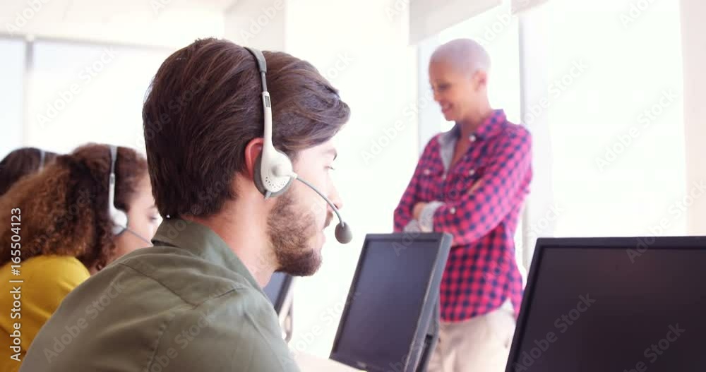 Customer service trainer monitoring her team Customer service trainer monitoring her team
