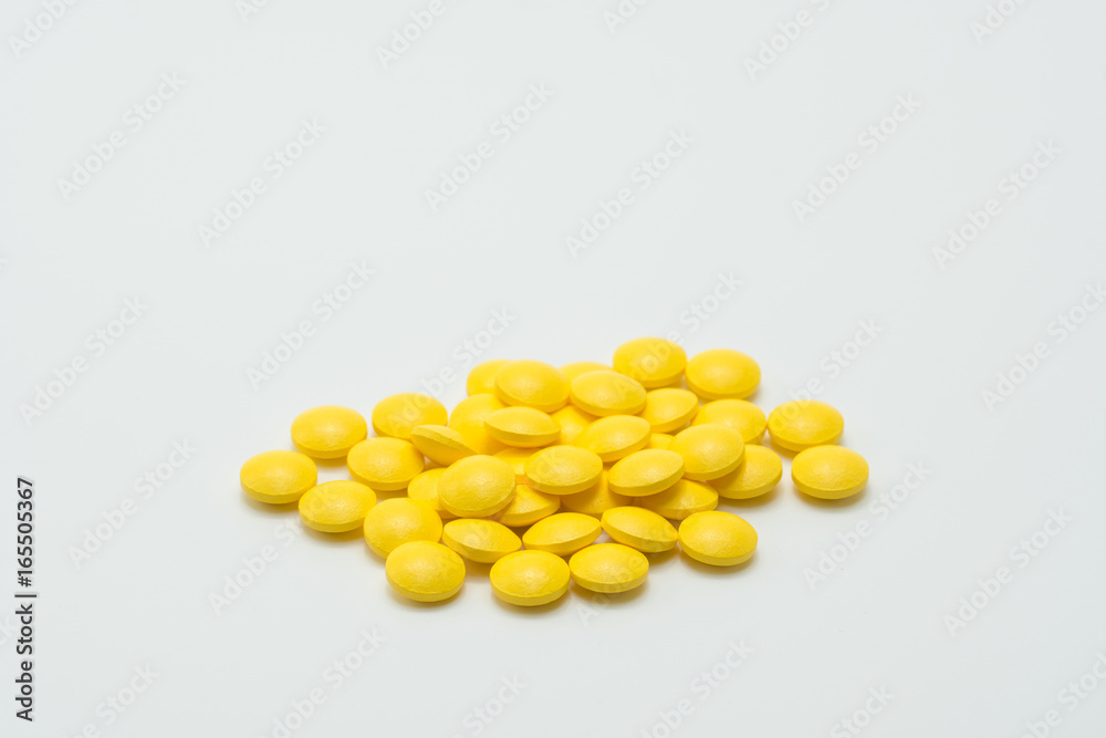 Yellow tablet pills on white background Yellow tablet pills on white background