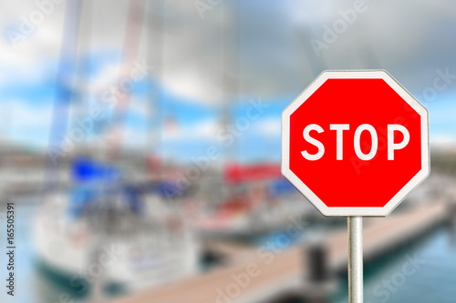 Red Stop sign on sailboat blurred background