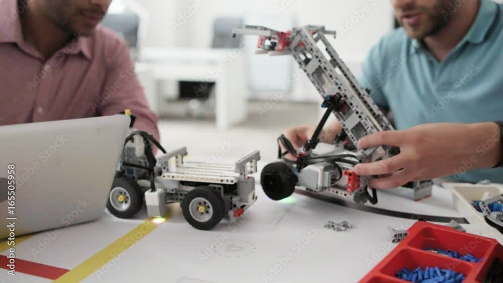 Two man testing robots in office Two man testing robots in office