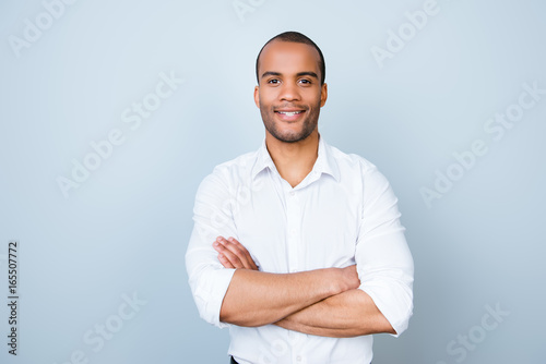 Foto Successful smiling young handsome american guy lawyer in formal outfit on pure background with crossed hands