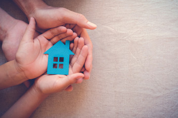 hands holding paper house, family home, homeless shelter, foster home care, family day care, mortgage housing crisis concept