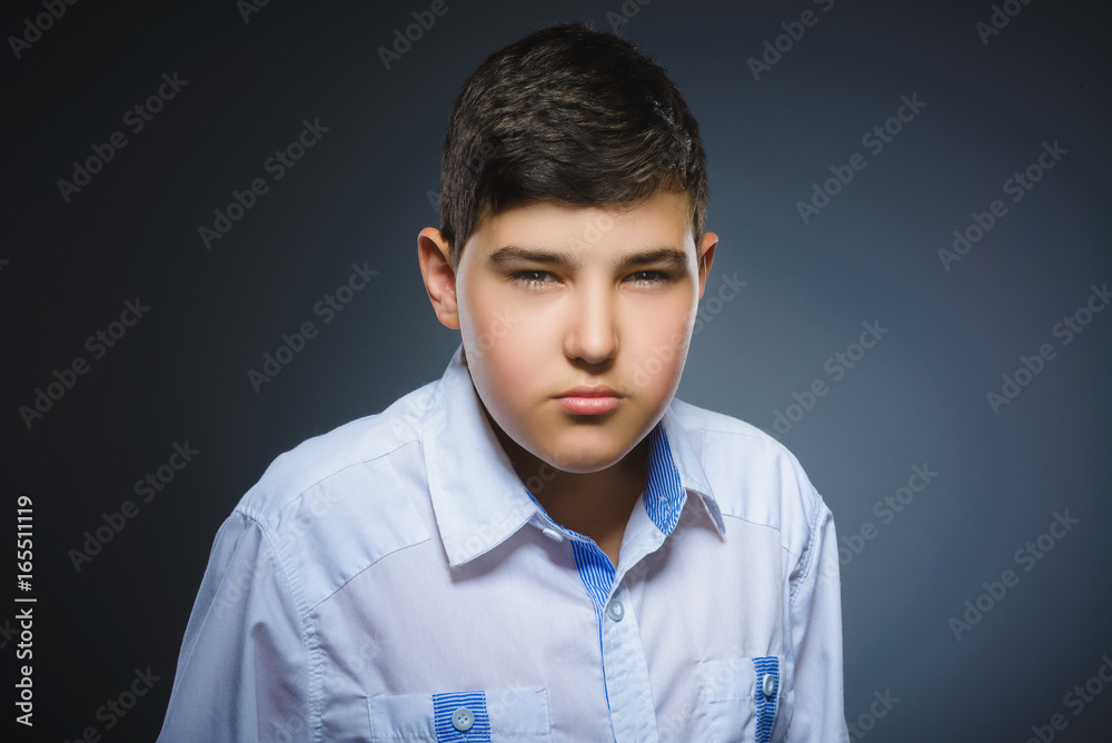 Obraz premium angry boy isolated on gray background. Closeup