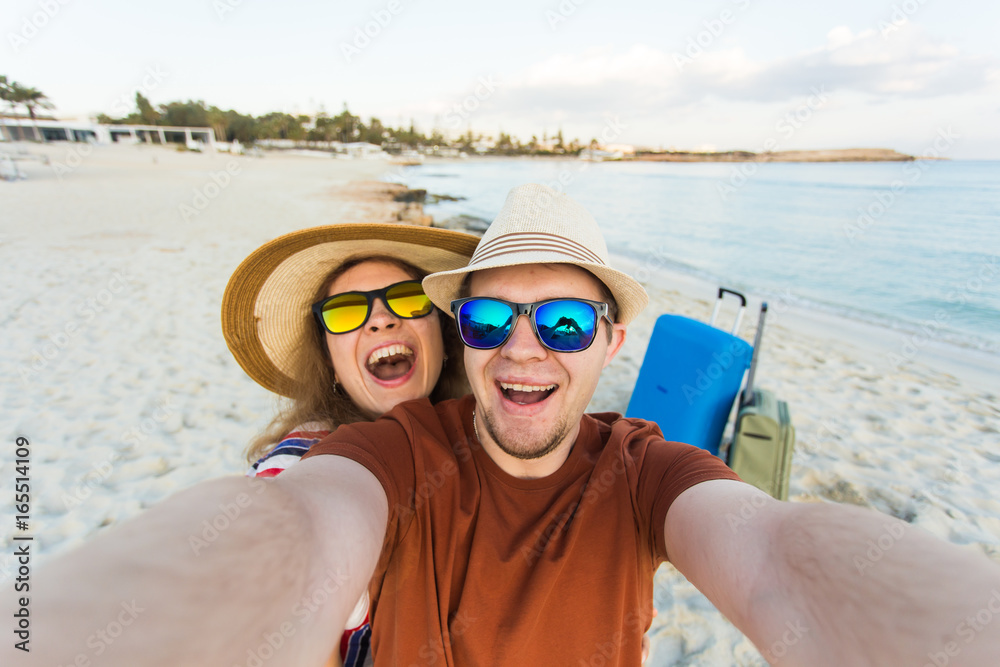 Happy traveling couple making selfie sea background , sunny summer colors, romantic mood. Stylish sunglasses, straw hat. Happy laughing emotional faces.
