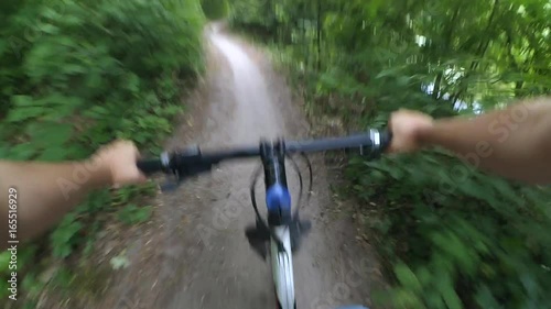 Riding fast on a bicycle in the forest, Hands on the wheel, Action camera go pro.