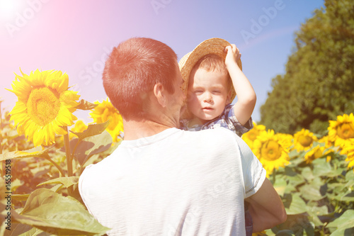 Father and son in sunflower field
