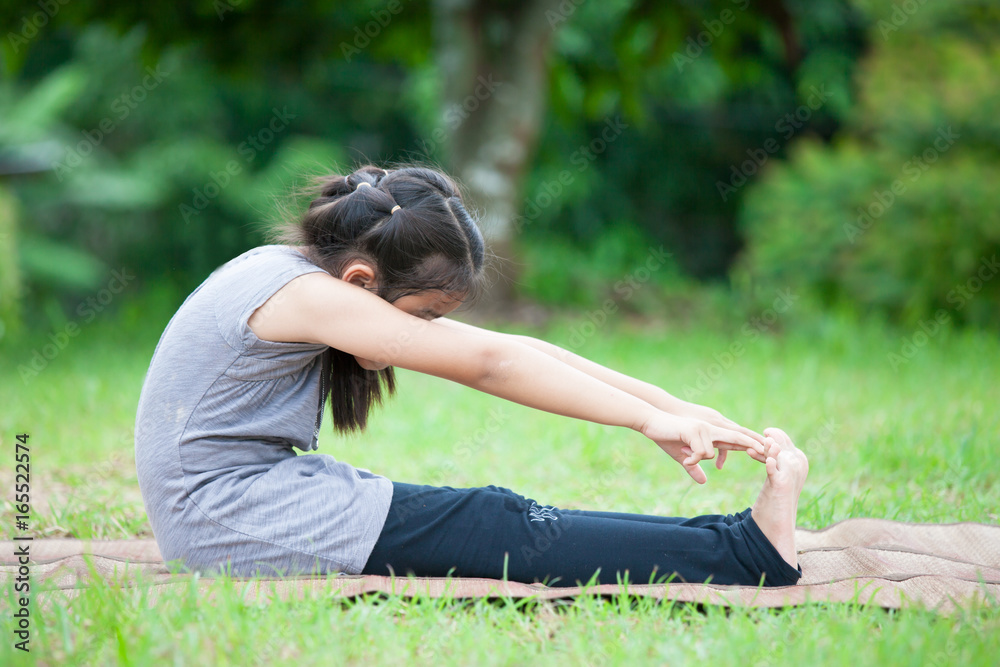 Asian child girl doing exercise in the summer park Asian child girl doing exercise in the summer park