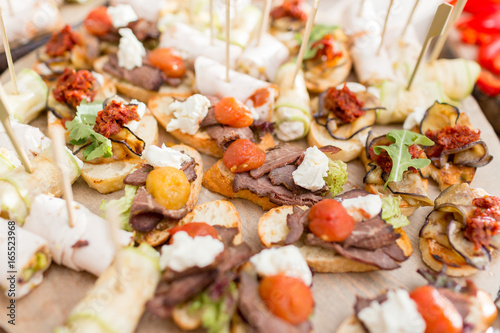 Assorted canape with cheese, meat, rolls, bakery and vegetables. selective focus