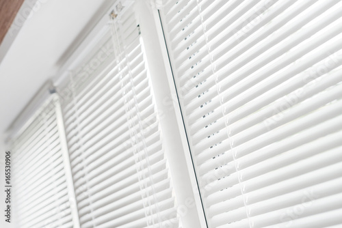 Windows with white venetian blinds. © M-Production