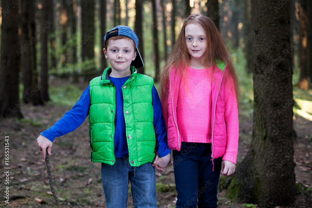 Boy and girl hold hands in the forest