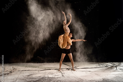 Young couple ballet dancing with powder in the stage