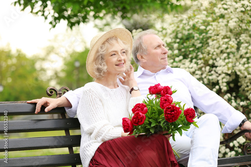 Happy senior couple sitting...