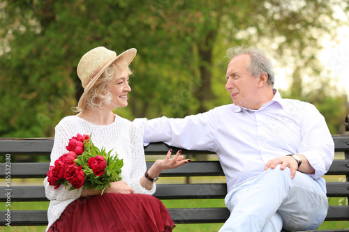 Happy senior couple sitting...