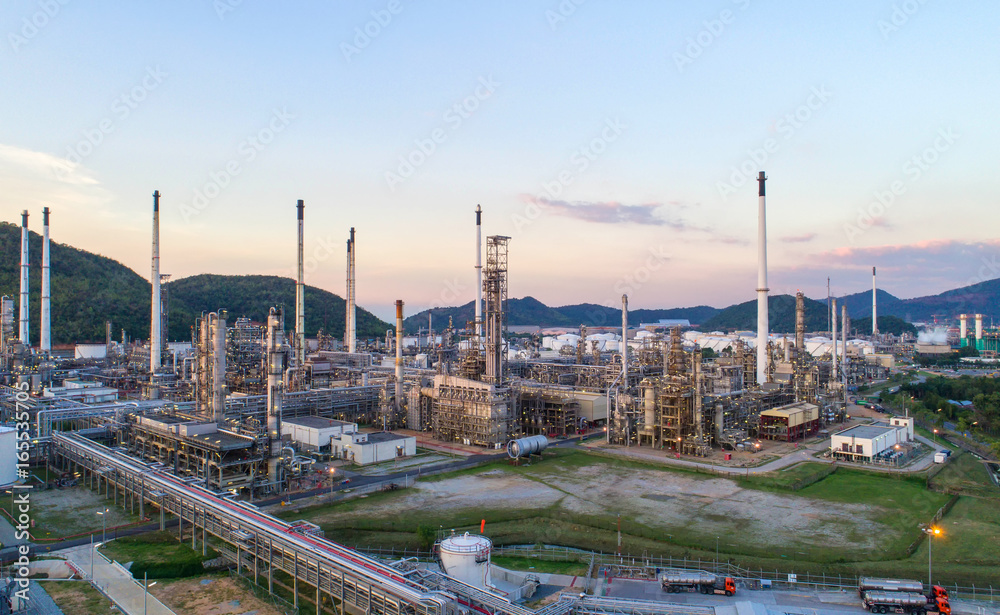 Obraz premium Aerial view Oil refinery with a background of mountains and sky.The factory is located in the middle of nature and no emissions. The area around the air pure.